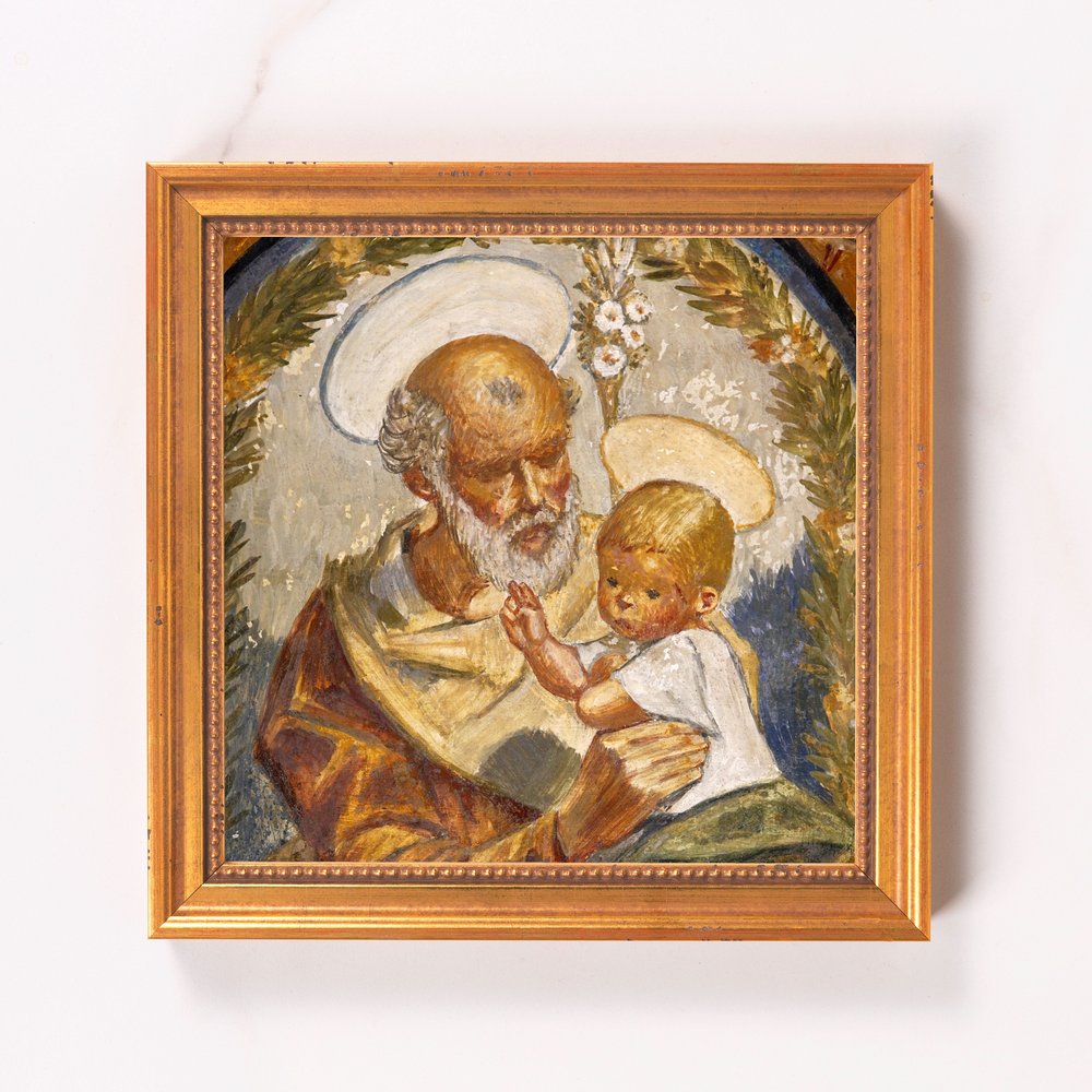 Framed painting of Saint Joseph holding baby Jesus with halo.
