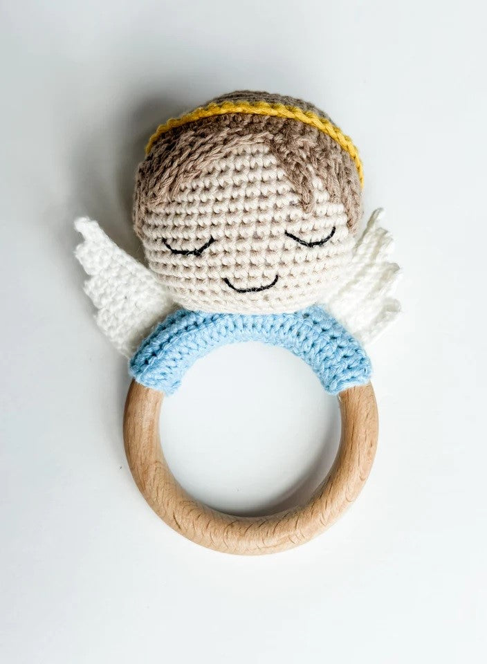 Angel baby rattle is crocheted with brown hair, a yellow halo, white wings, and blue collar around a wooden ring.
