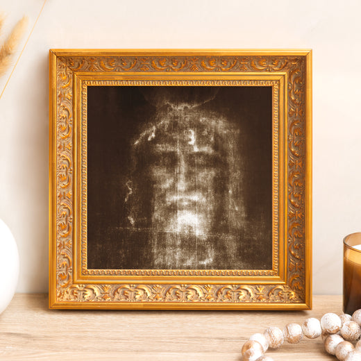 Framed shroud depicts the face of Jesus in a gold ornate wood frame.
