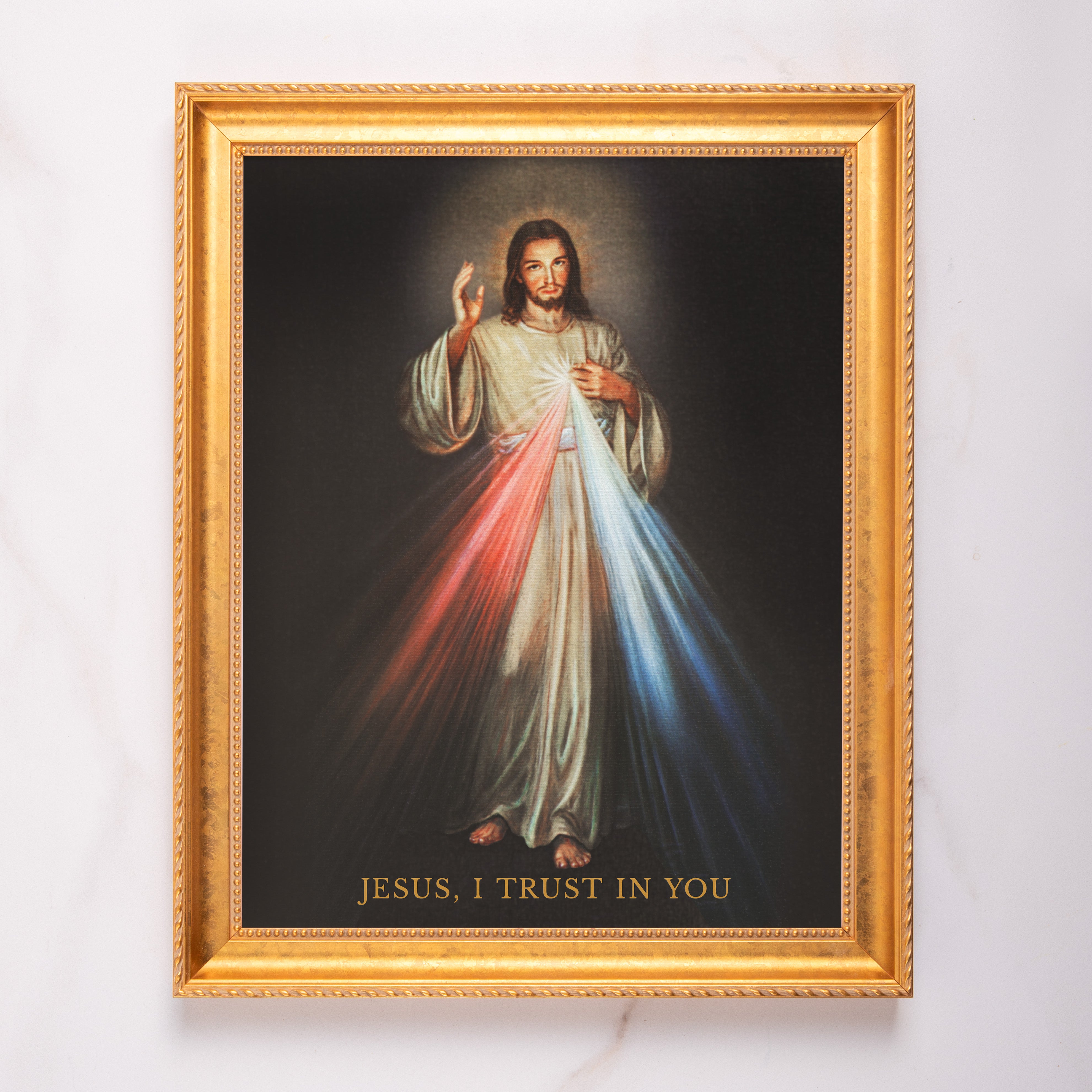 Framed "Jesus, I Trust in You" print in a decorative gold frame with a religious subject.