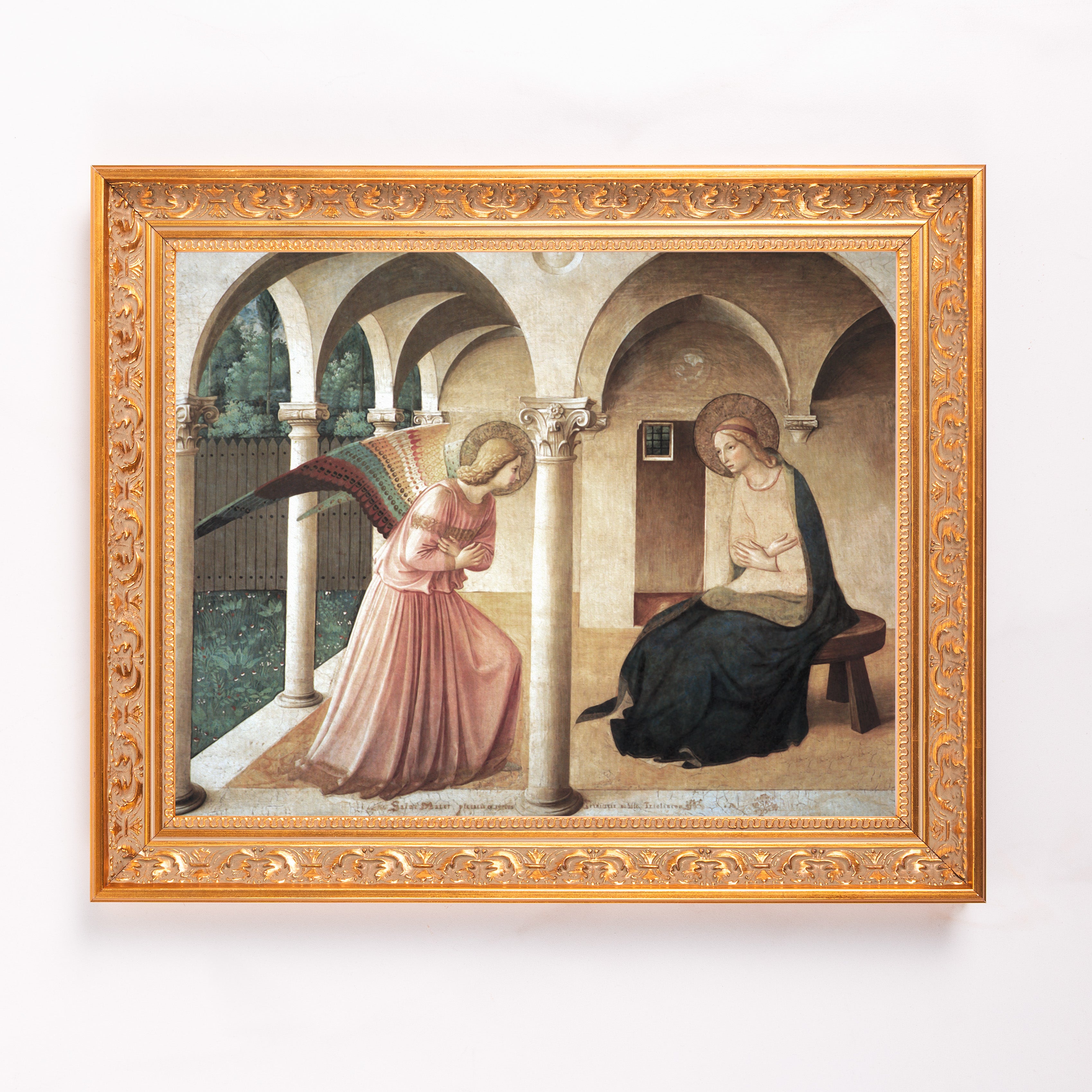 Framed Annunciation painting featuring angel and Virgin Mary in ornate gold frame.