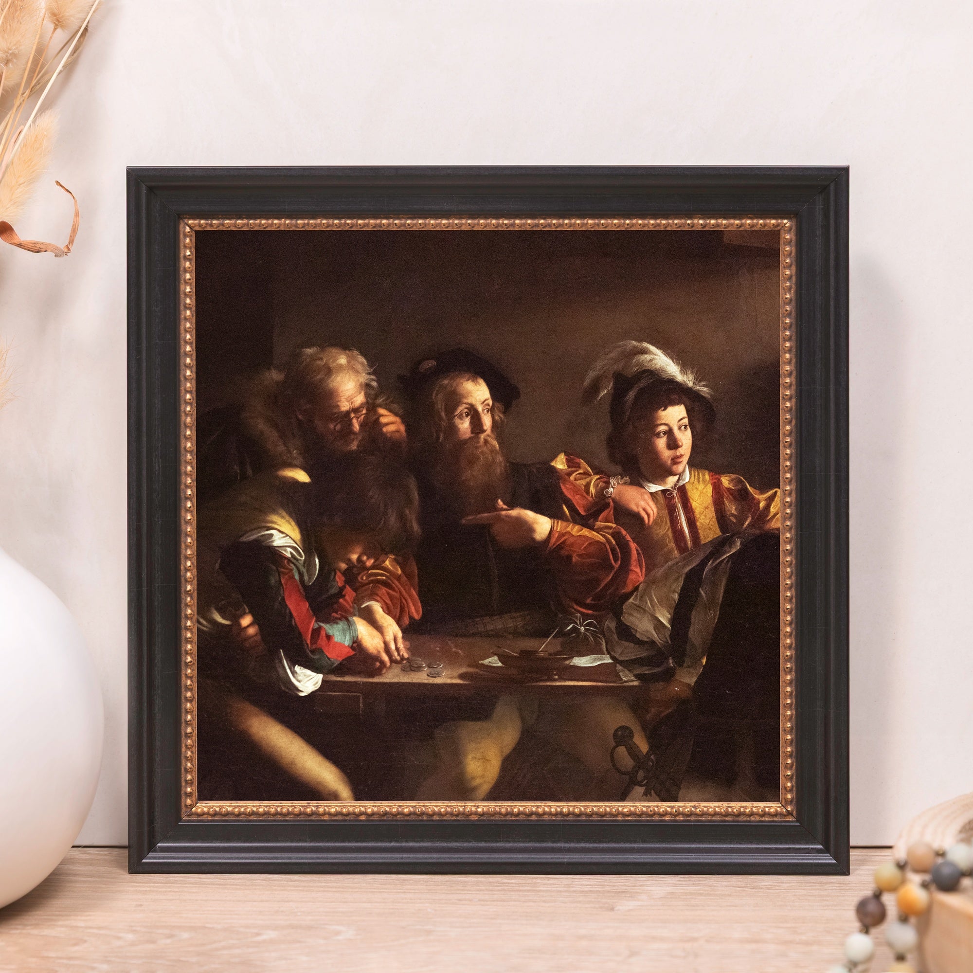 Framed print of old master painting, featuring cardsharps, in dark frame with gold trim.