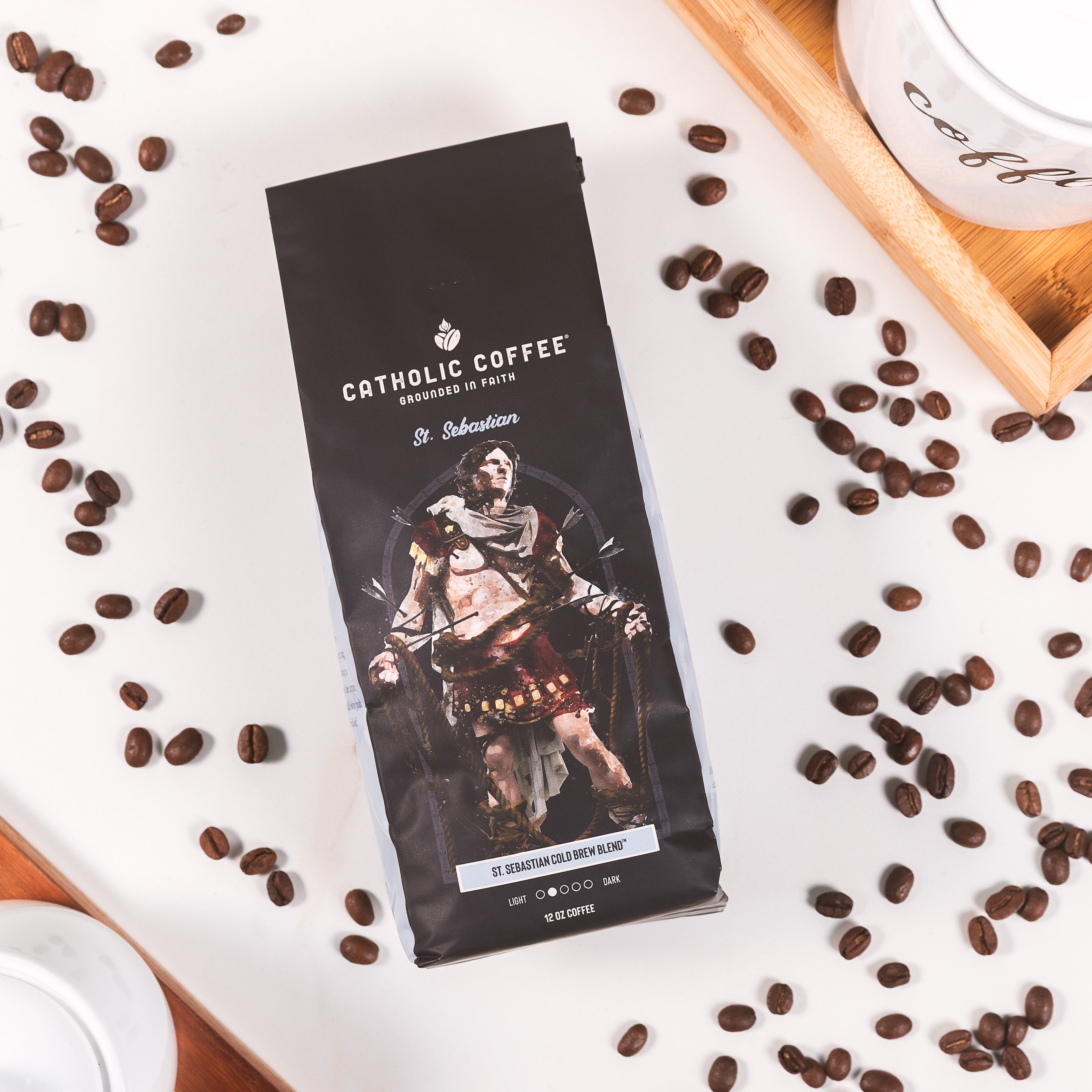 Black Bag of Catholic Coffee "St. Sebastian Cold Brew Blend" with an illustration of St. Sebastian tied with ropes and pierced with arrows.