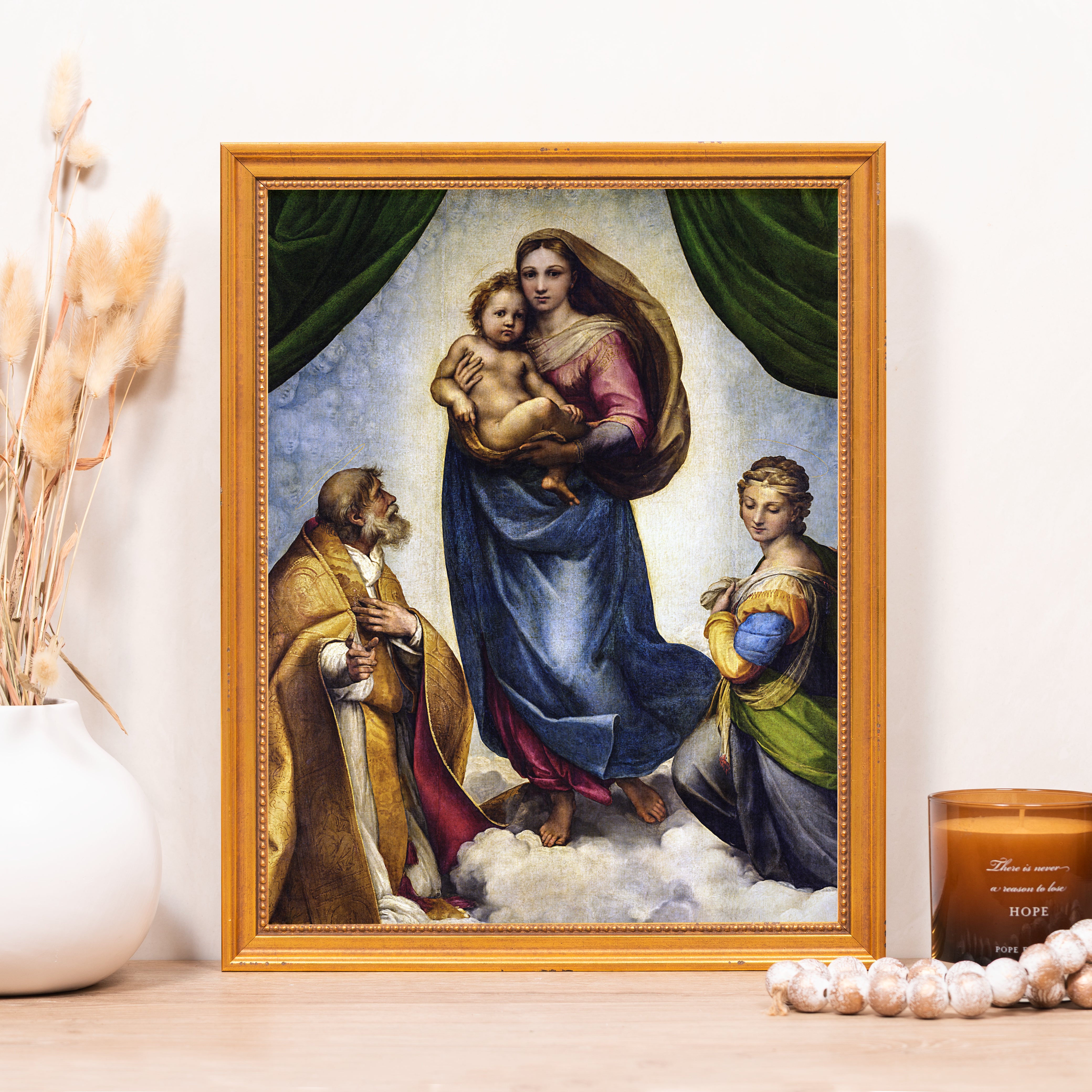 Framed print of the Sistine Madonna art in a gold frame, depicting the Virgin Mary with Jesus.
