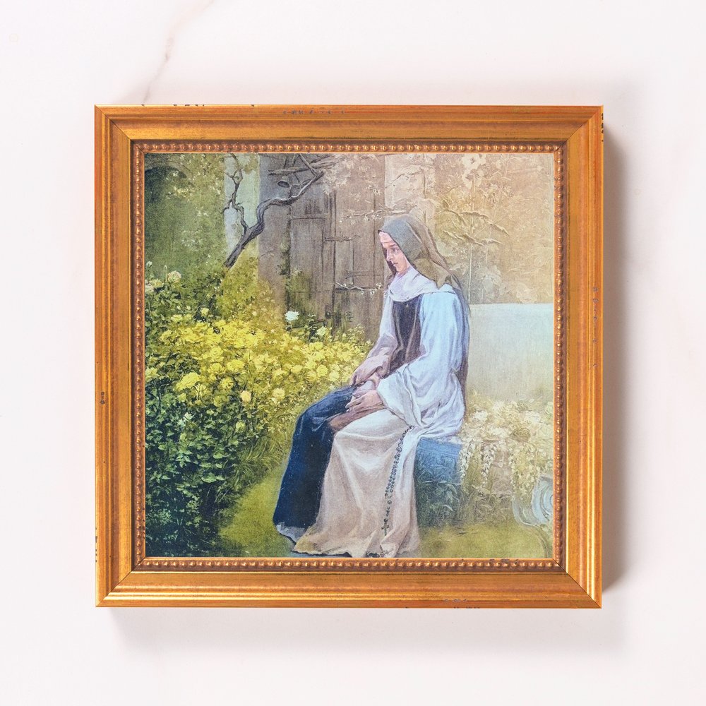 Framed print of a nun in a garden, gold frame, classical style.