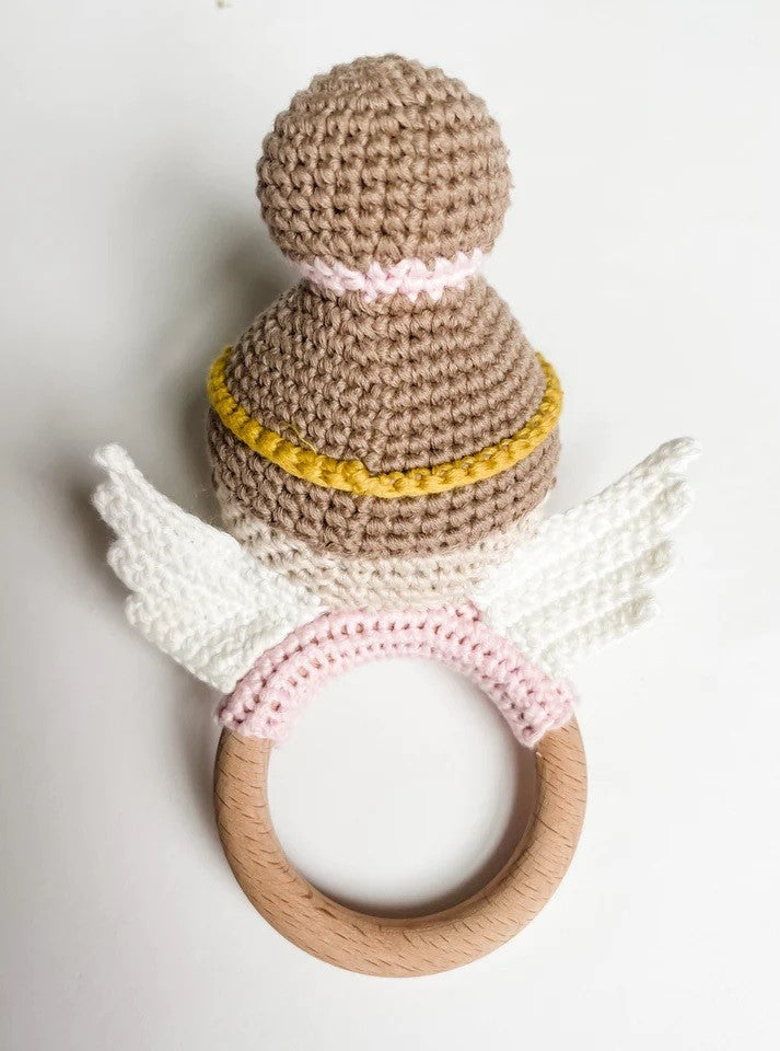 Crocheted angel baby teether with wooden ring and white wings.