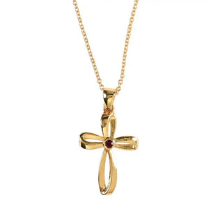 Gold-colored cross necklace with a small red gem in the center and a delicate chain.